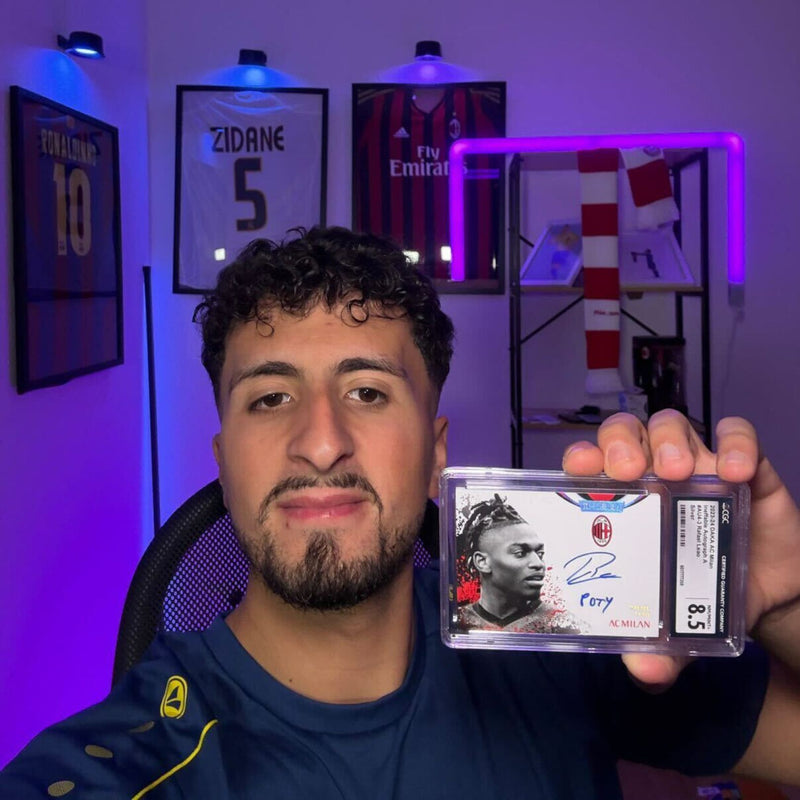 Kunde Karim zeigt eine gegradete Autogrammkarte in seinem Sammlerzimmer