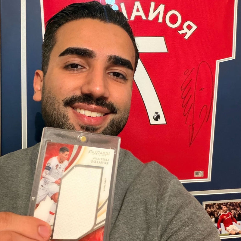 Kunde Ramtin mit einer gegradeten Sammelkarte vor einem signierten Ronaldo-Trikot